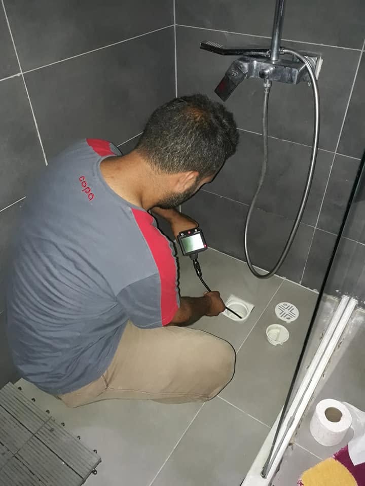 Lavabo altında boru bağlantısı sıkan tesisatçı